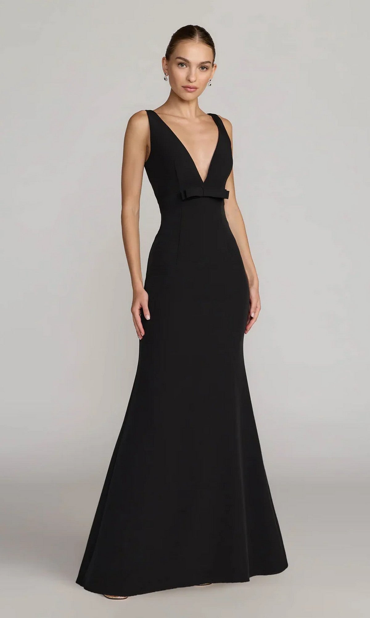 A woman wearing the Mac Duggal 2371 long formal dress, a sleeveless crepe evening gown with a deep V-neckline and fitted silhouette, stands against a plain light background.